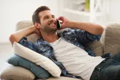 Gay man lying down talking on a mobile phone