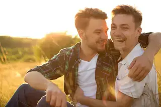 Two gay men hugging in a field