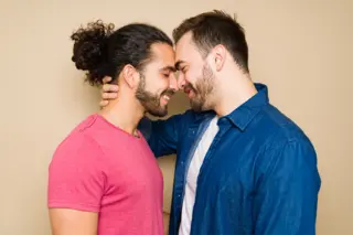 Two happy gay men with their forehead's touching